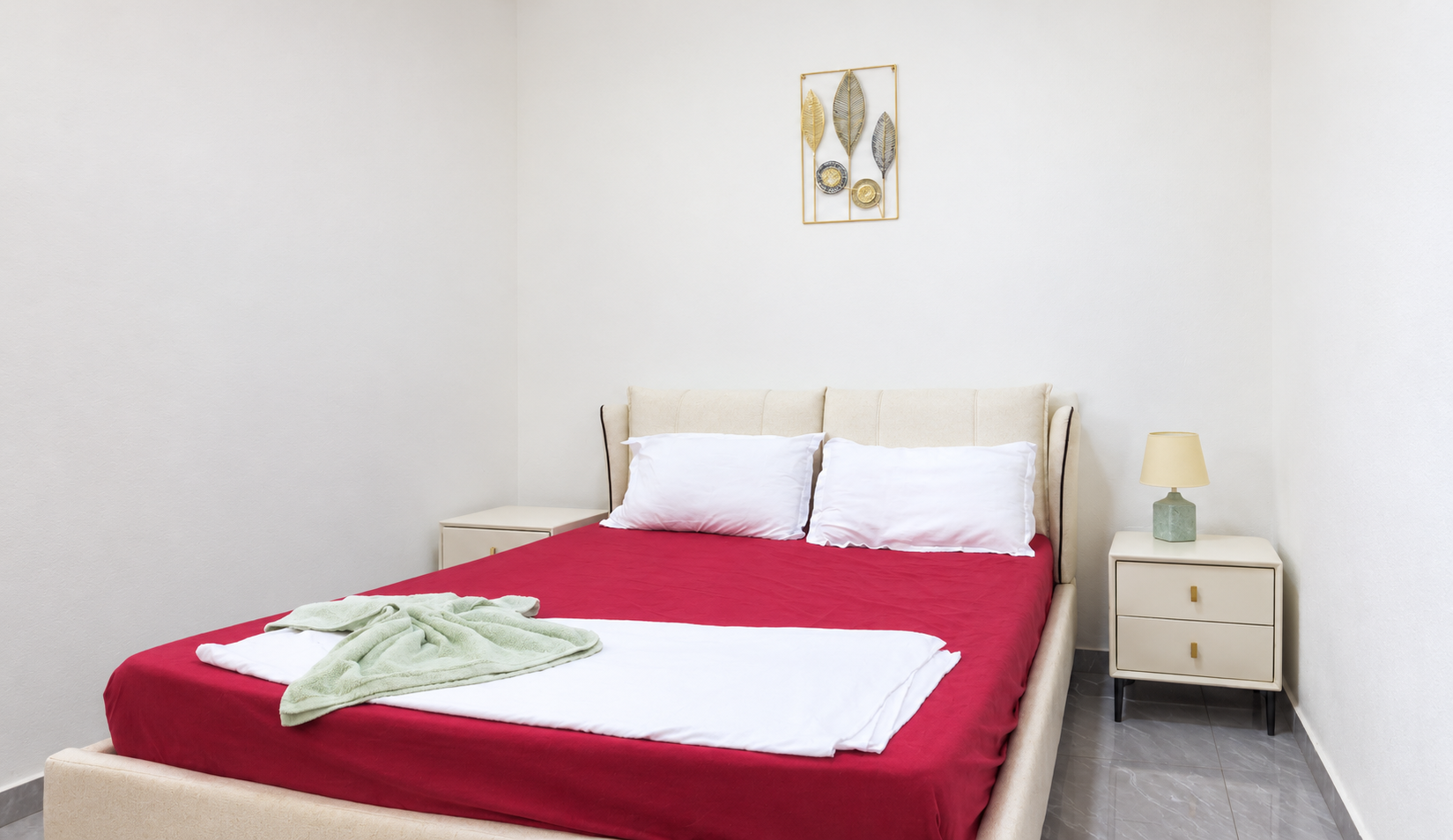 Segundo quarto do apartamento com cama de casal e decoração neutra